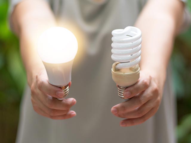 Eine Person hält eine LED Birne und eine Glühbirne in der Hand