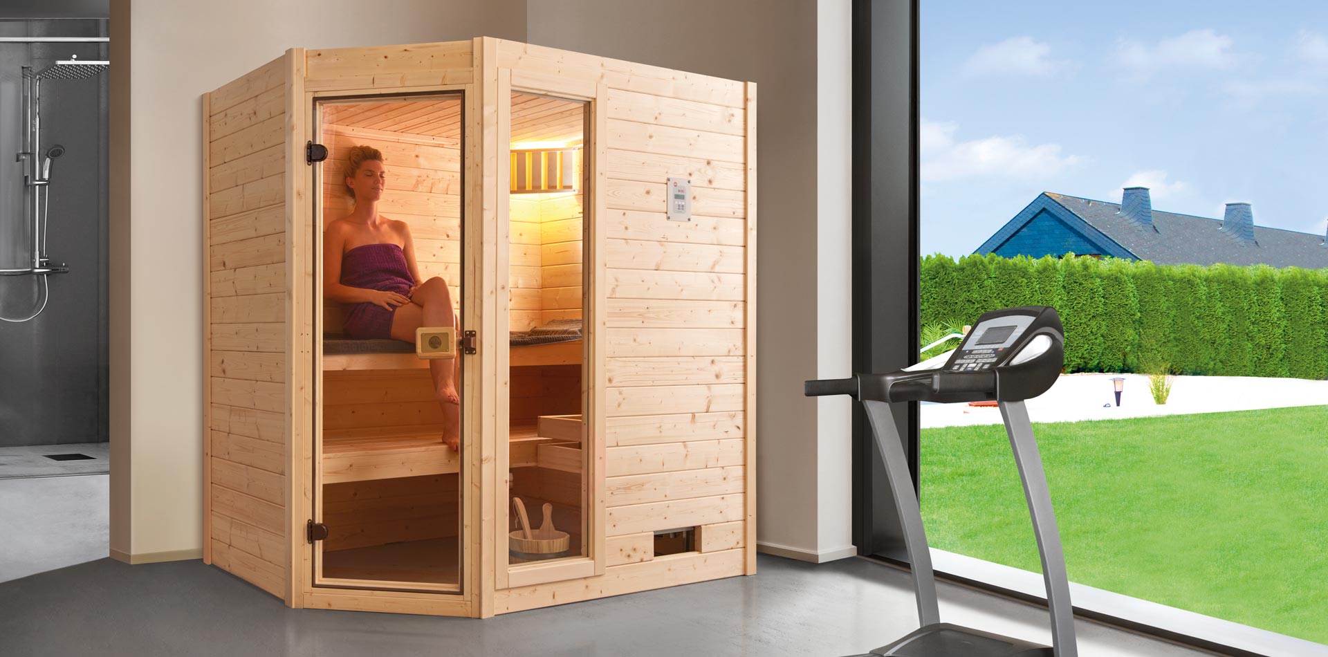 Sauna mit Glastür und Fensterelement, in der eine Frau sitzt, in einem Fitnessbereich