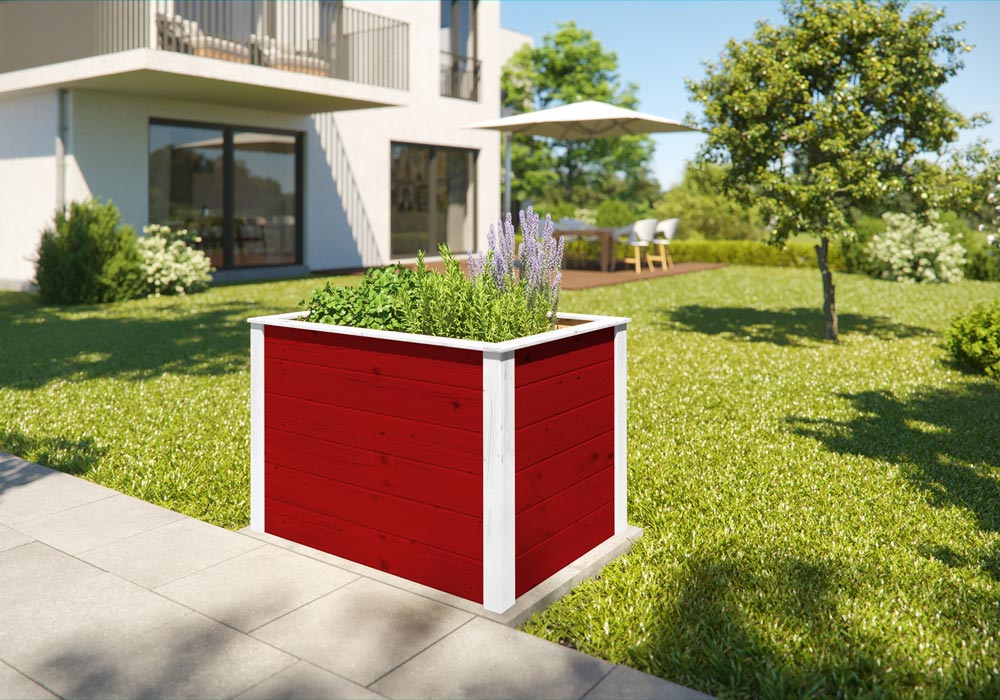 Ein rotes bepflanztes Hochbeet mit weißen Rahmenholz in einem Garten