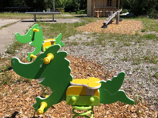 Zwei Federwippen in Form des Zeichentrick-Drachens Tabaluga auf einem Spielplatz