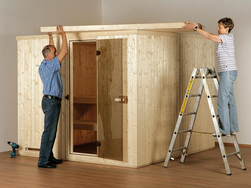 Mann und Frau platzieren die Deckenelemente einer Indoor-Sauna